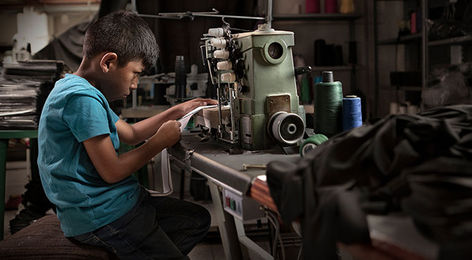 Fotografía de niño haciendo trabajos de costura