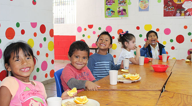 Fotografía de niños comiendo en instalaciones de Save The Children
